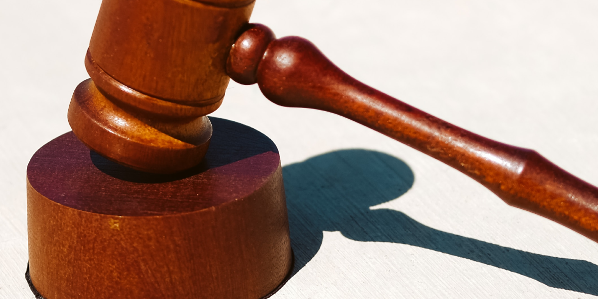 A wooden gavel rests on its sound block in a close-up image.